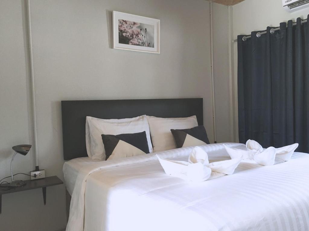 班柯木MOOK BOONCHU HOTEL的一张白色大床,配有白色床单和枕头