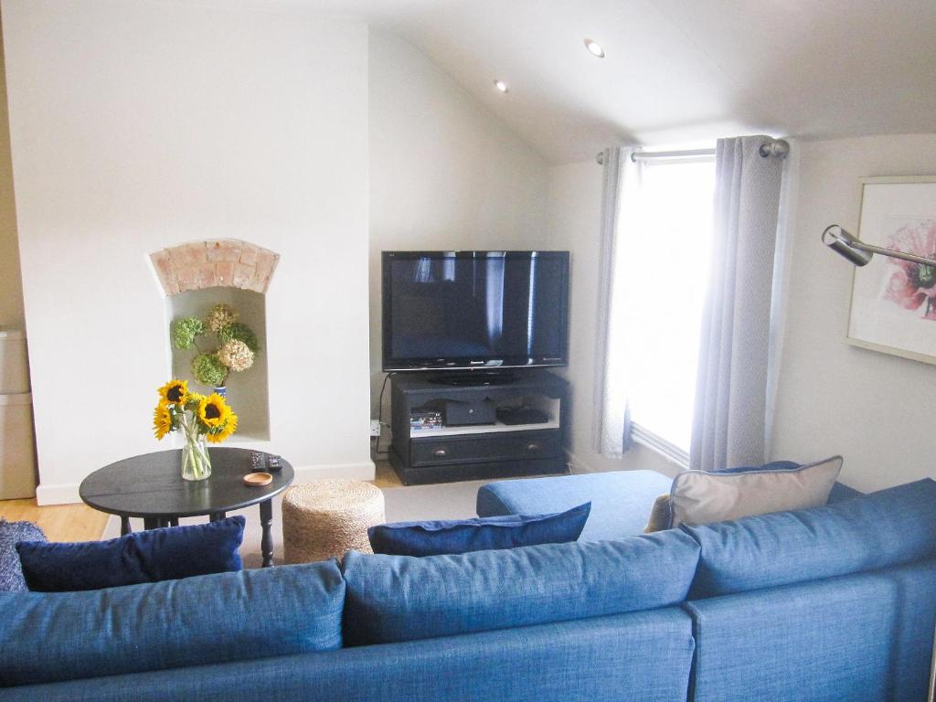 格洛斯特Priory Place的客厅配有蓝色的沙发和电视