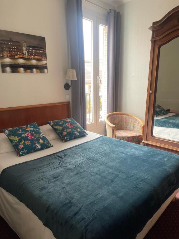 巴黎魏尔伦酒店的一间卧室配有一张带蓝色毯子和镜子的床