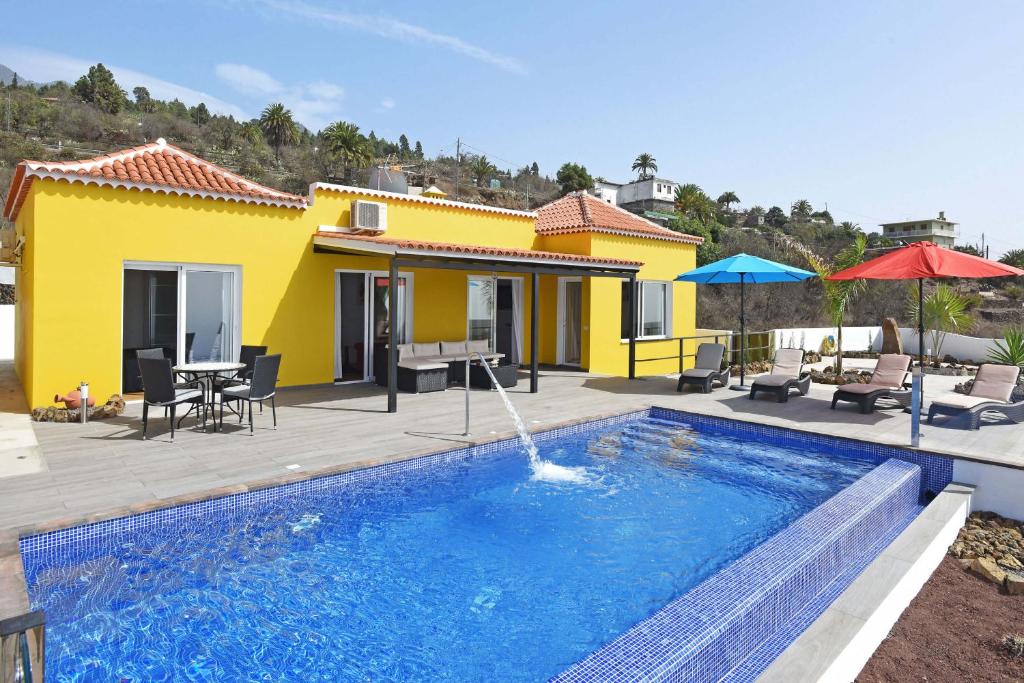 蒂哈拉费Casa Diamante的黄色房子前面的游泳池