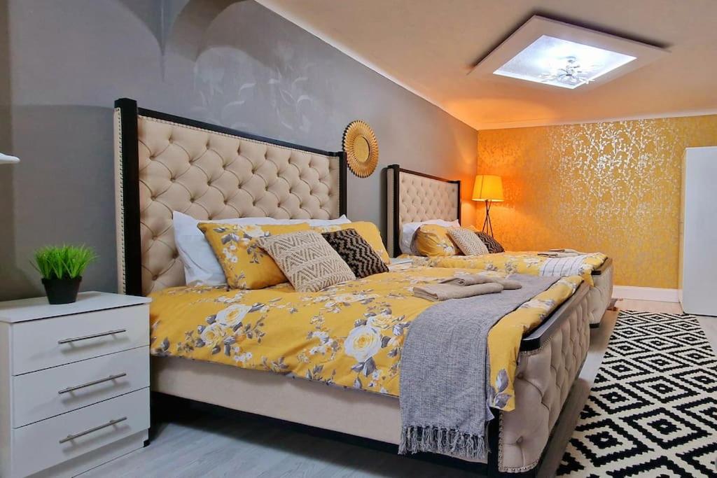 Coundon4 bedroom House Coventry Sleep 9 + 3Parking spaces的一间卧室配有一张带黄色床罩的大床