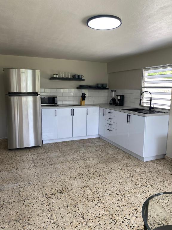 卡沃罗霍Casa Isabela En Cabo Rojo的厨房配有白色橱柜和不锈钢冰箱