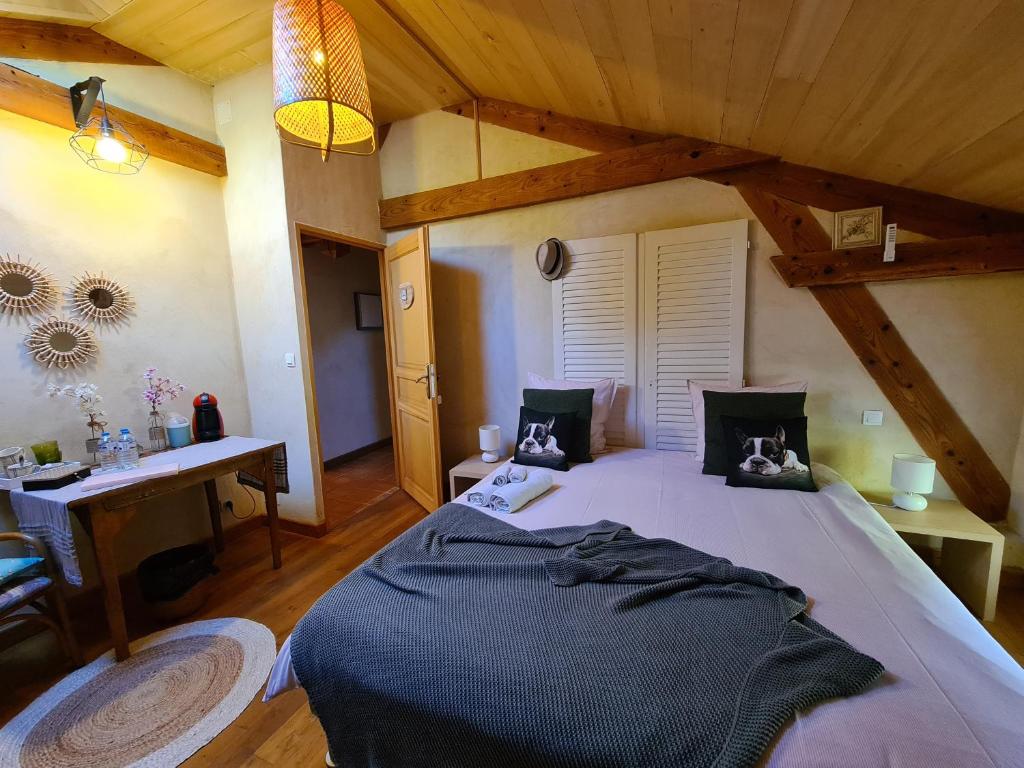 Saint-Sylvestre-sur-LotLe Coq en Repos的一间卧室配有一张大床和一张书桌