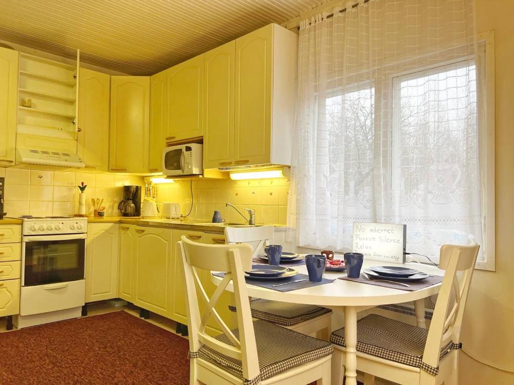 拉彭兰塔Finnish house near the forest的厨房配有黄色橱柜和桌椅