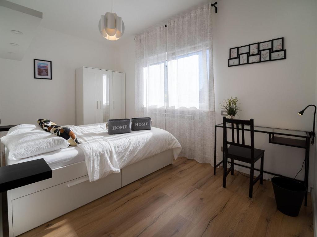 乌迪内Casa Felicità的白色卧室配有床和椅子