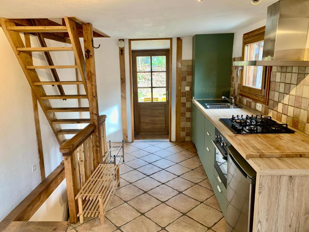 夏蒙尼-勃朗峰Gorgeous Mini-Chalet Chamonix的厨房设有楼梯,通往带炉灶的厨房