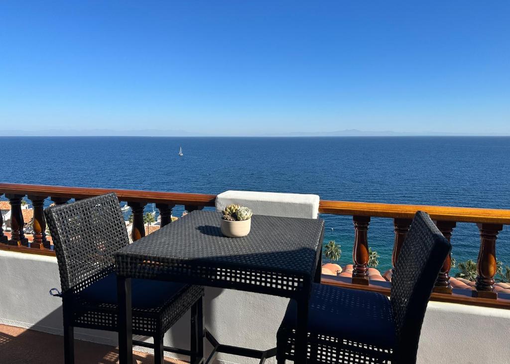 阿瓦隆Premium Ocean Corner Unit, Fireplace, Golf Cart, 21 Steps from Top的俯瞰大海的阳台配有桌椅