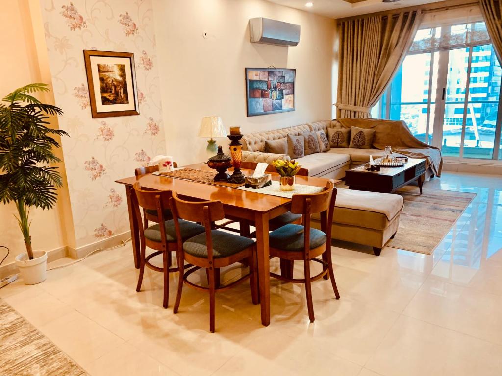 伊斯兰堡Elysium Service Apartment 1203的客厅配有桌子和沙发