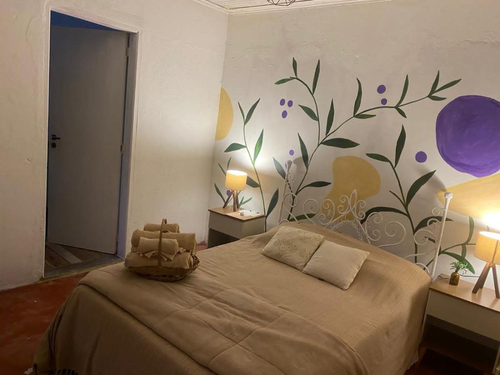 阿蒂巴亚Sitio Anju的卧室配有一张挂着花壁画的床。