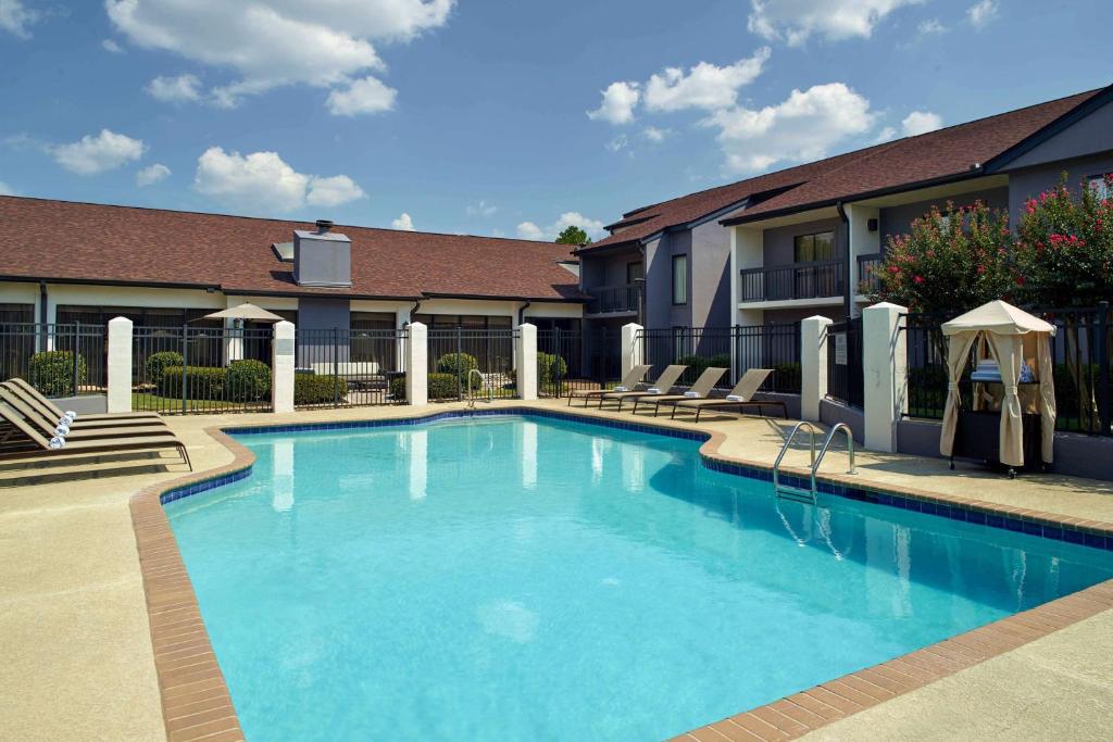 诺克罗斯Sonesta Select Atlanta Norcross I 85的一座带椅子的大型游泳池和一座建筑