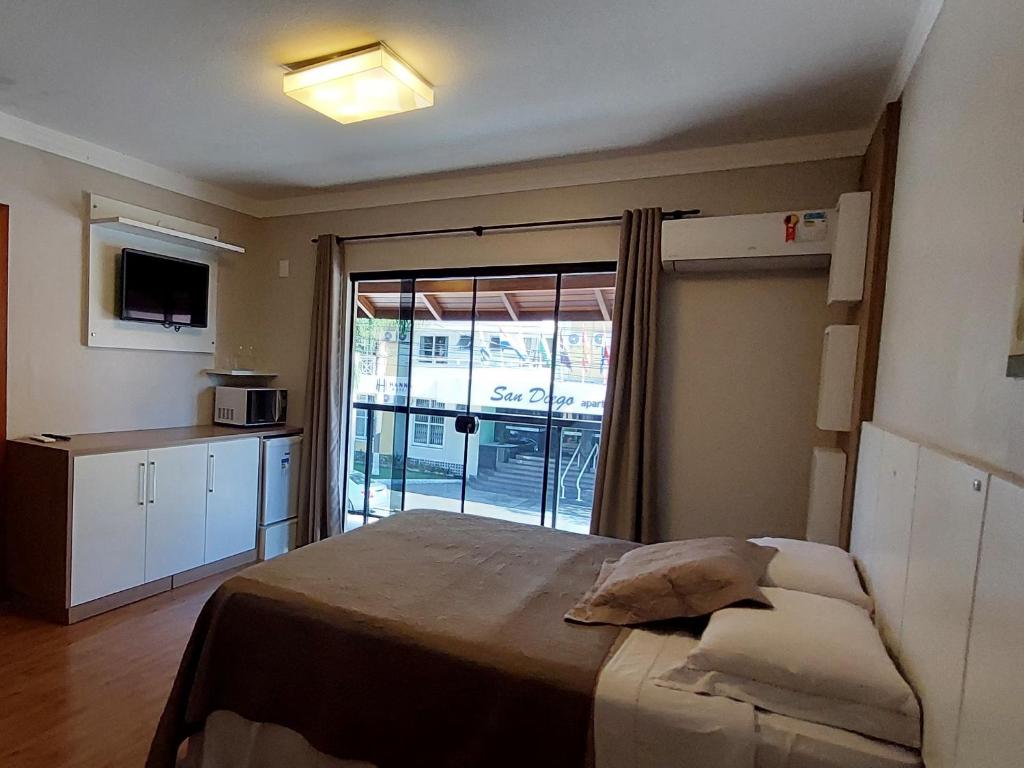 弗洛里亚诺波利斯Pousada Casa Da Praia的一间卧室设有一张床和一个滑动玻璃门
