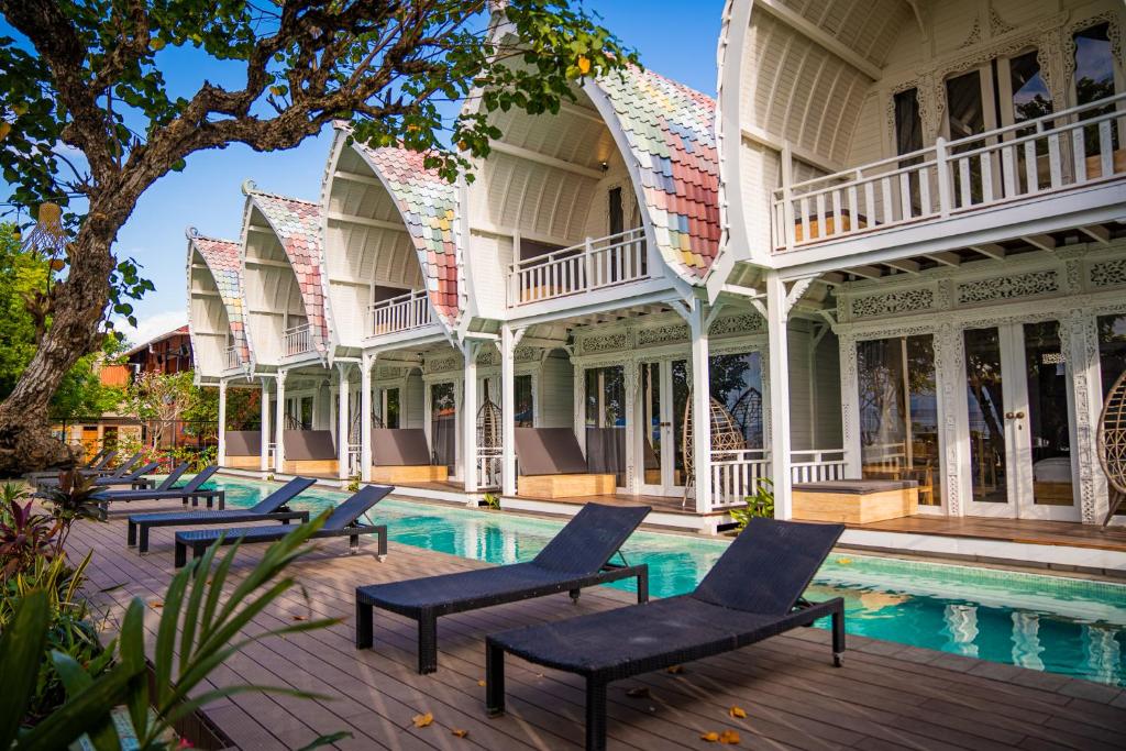 珀尼达岛Mambo Beach Resort的一座带椅子的古老大厦,环绕着游泳池