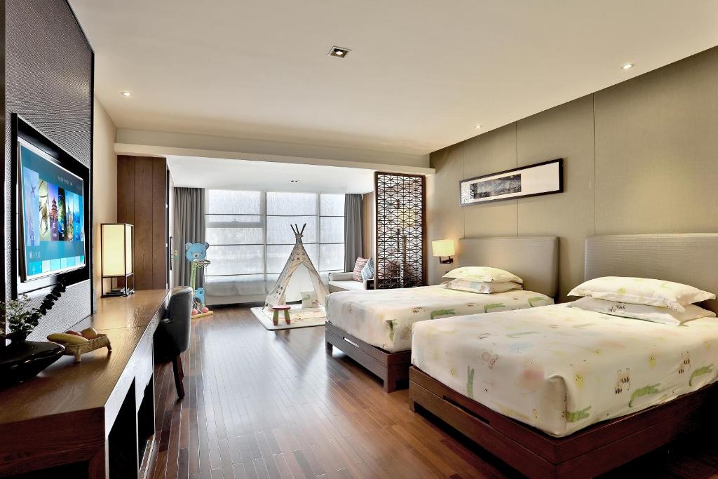 杭州杭州野风君亭酒店的一间卧室配有两张床和一台平面电视