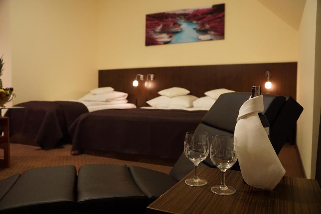 罗兹尤卡酒店的酒店客房,设有两张床和一张带酒杯的桌子
