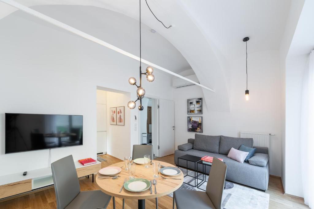 格拉茨Premium Apartments im Stadtzentrum的客厅配有桌子和沙发