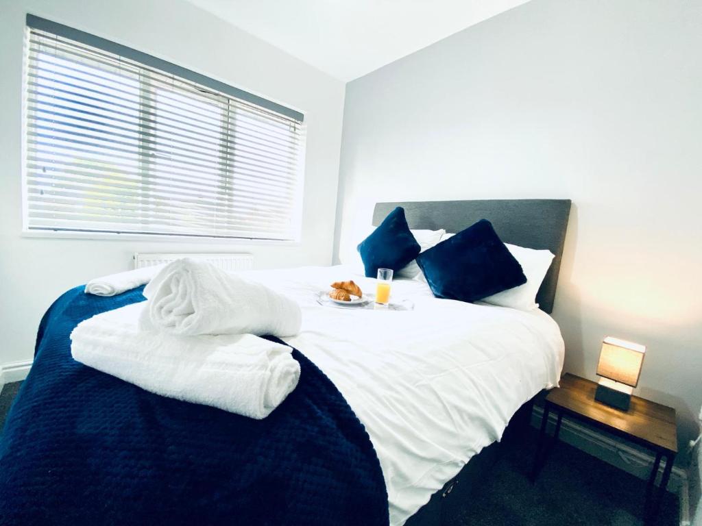 海塞HU-Thirteen Apt Two- Sleeps 4的卧室配有带蓝色枕头的大型白色床
