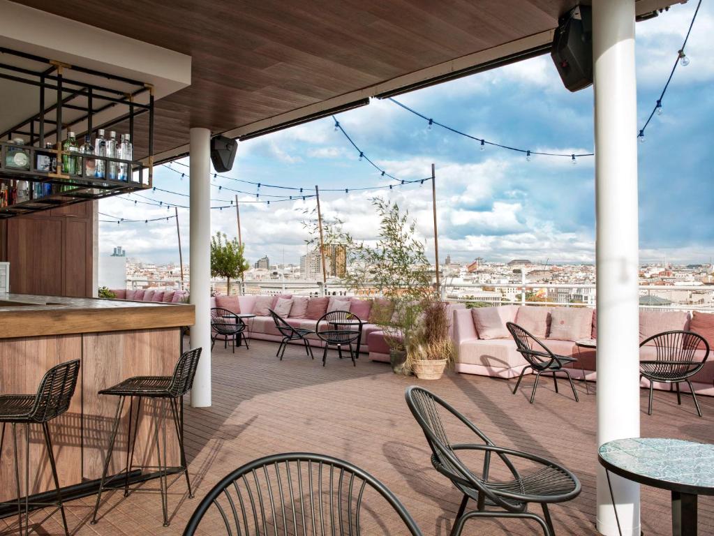 马德里马德里苏西亚NH酒店的一个带桌椅的庭院和一间酒吧