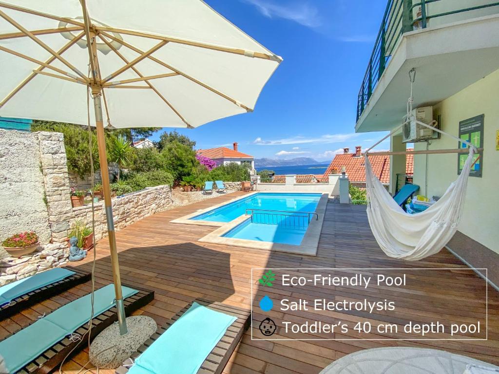 鲁巴达Eco Sunshine Apartments Lumbarda的一个带吊床的庭院和一个游泳池