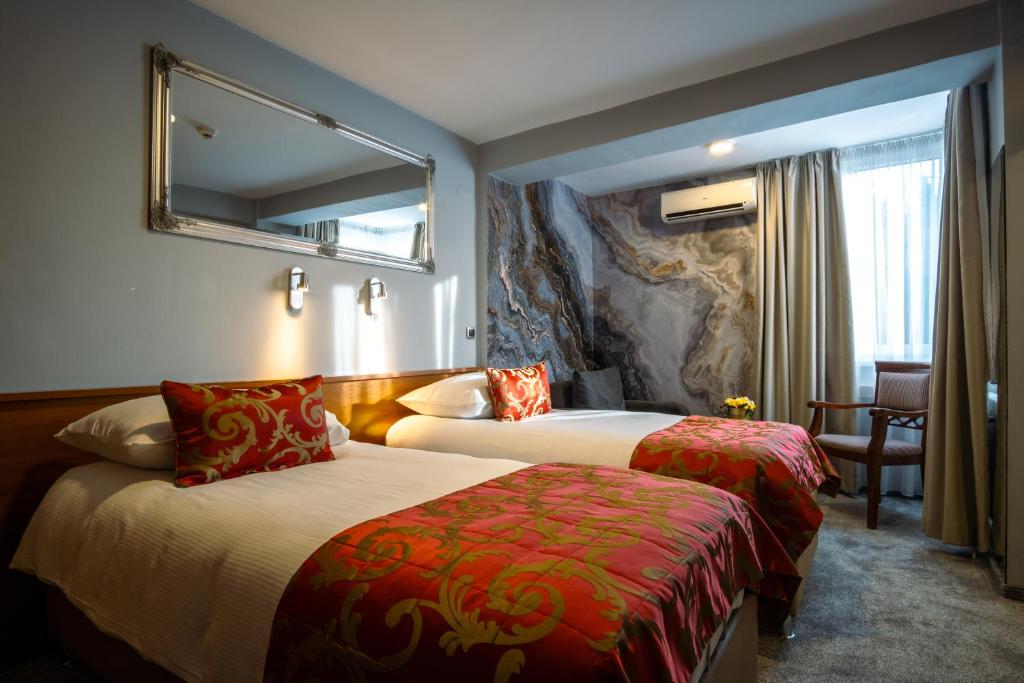 萨拉热窝Hotel Villa Harmony的酒店客房,设有两张床和镜子