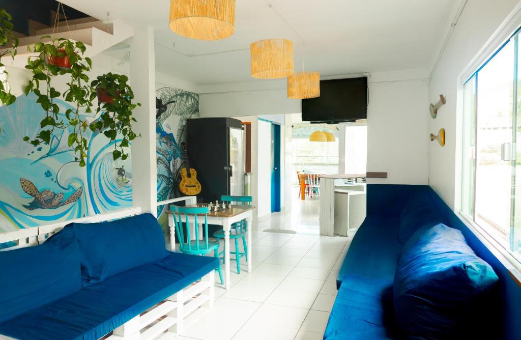 弗洛里亚诺波利斯Sea Wolf Surf Hostel的一间带蓝色沙发的客厅和一间厨房