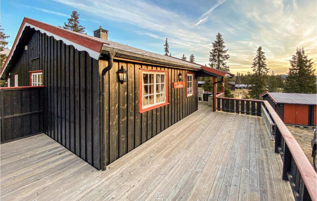 斯朱森3 Bedroom Stunning Home In Sjusjen的木制甲板上设有小小屋