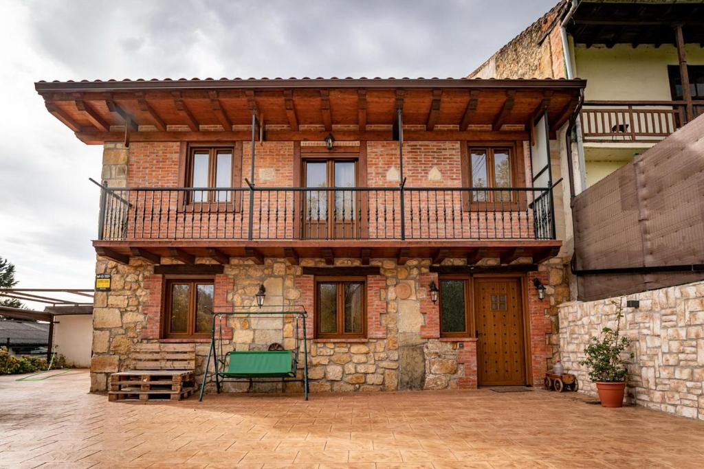 Hoz de AneroCasa Rural La Magdalena的砖屋,上面设有阳台
