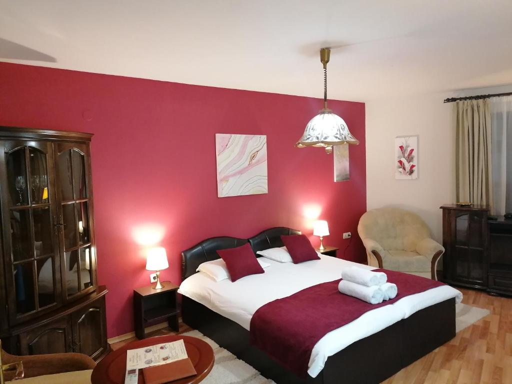 布拉戈耶夫格勒Petkov Family Hotel的一间卧室配有一张红色墙壁的床