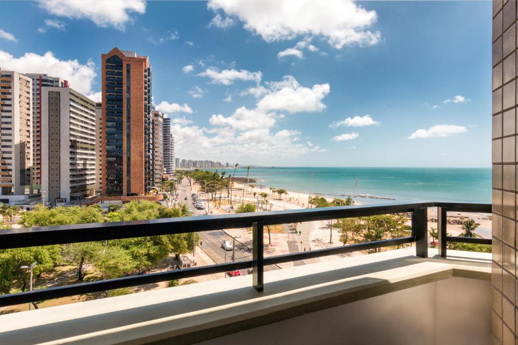 福塔莱萨Particular Golden Beira Mar的享有海滩和建筑景致的阳台