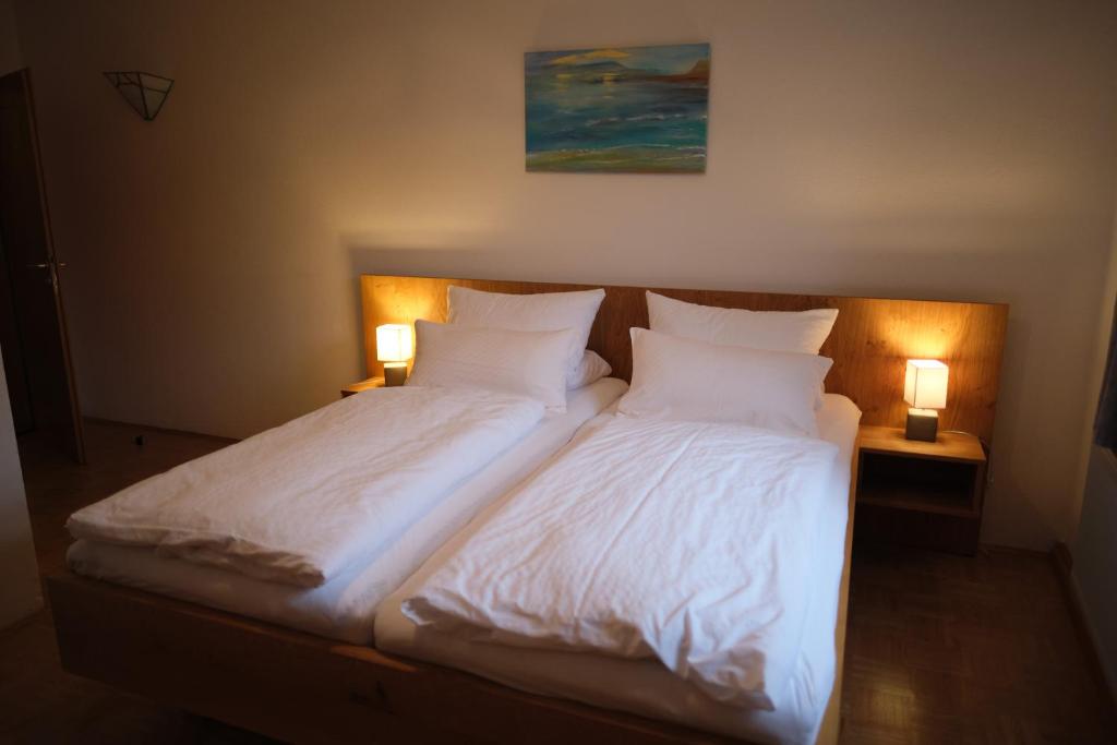 FürsteneckWirtshaus Im Schloss Fürsteneck的一间卧室配有两张带白色床单和两盏灯的床。