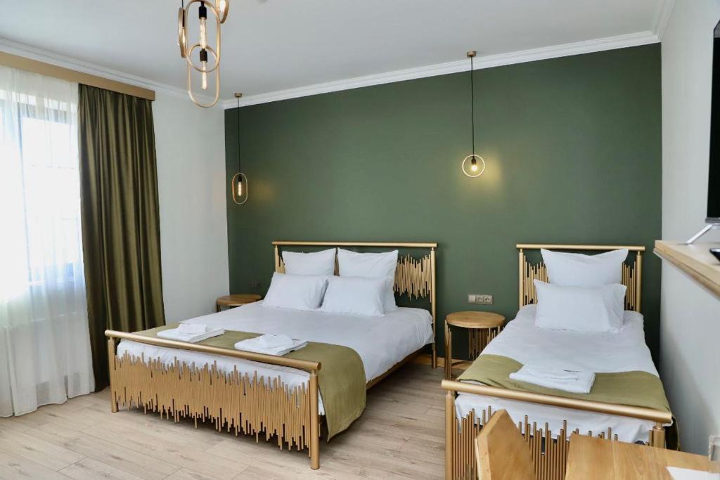 塞凡Sargsyan ECO house的一间卧室设有两张床和绿色的墙壁