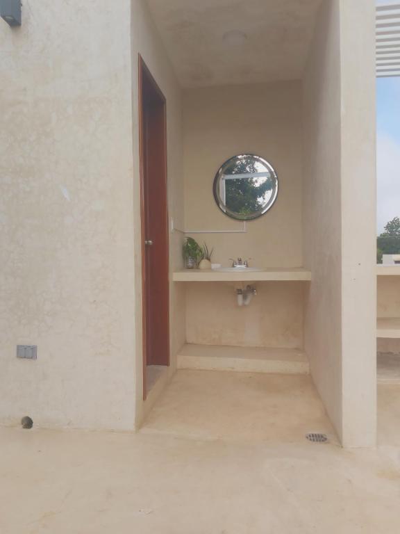 巴卡拉尔Azul 36 Hotel的一间带水槽和圆形窗户的浴室