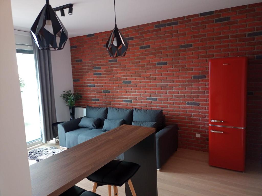 萨格勒布Arena ZG Apartment的一间设有砖墙和木桌的客厅