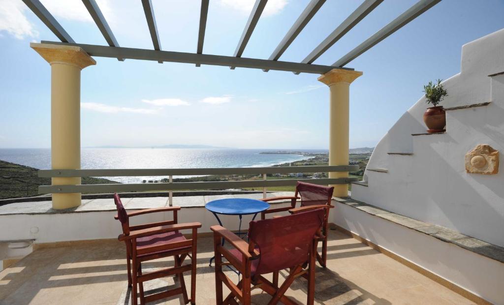 提诺斯Tinos View Apartments的海景阳台上的桌椅