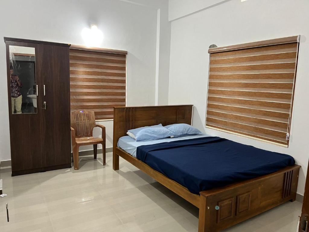 卡尔佩特塔Wayanad Biriyomz Residency, Kalpatta, Low Cost Rooms and Deluxe Apartment的卧室配有床、椅子和窗户。