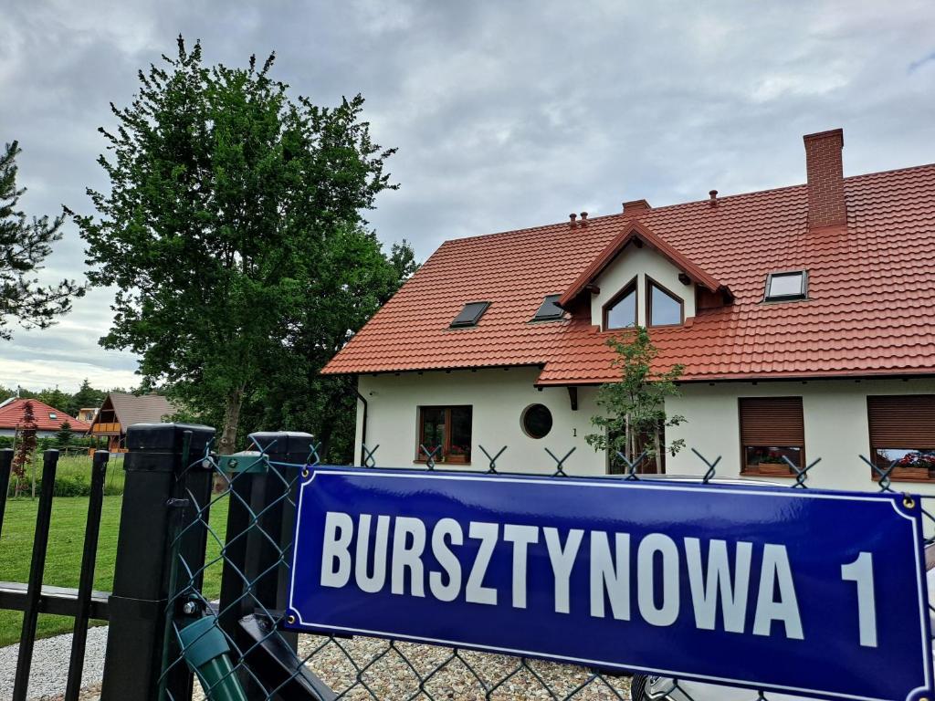 斯图托沃Bursztynowa 1的房屋前的栅栏上的一个蓝色标志