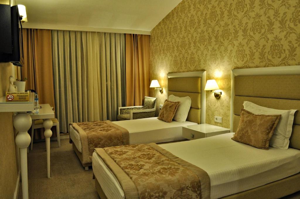 埃迪尔内埃迪尔内宫殿酒店的酒店客房,配有两张床和椅子