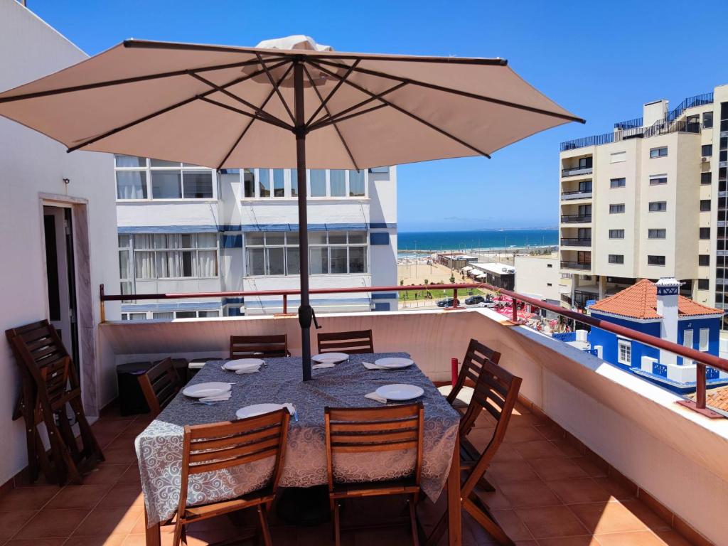 卡帕里卡海岸Amazing Terrace Costa da Caparica的阳台上配有带雨伞的桌子