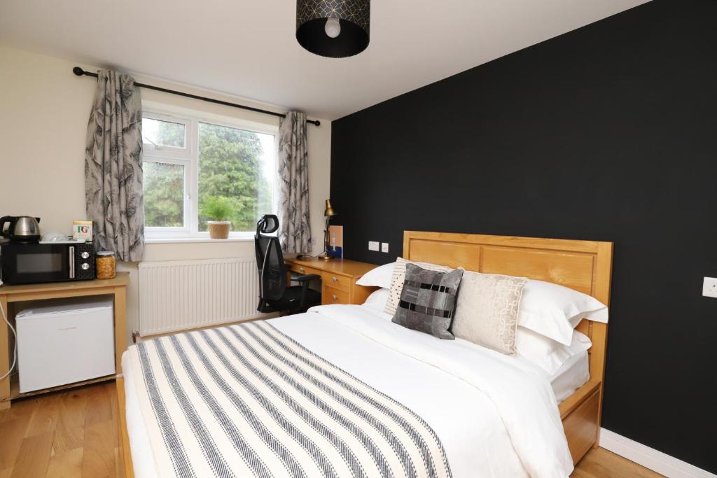 牛津Luxurious double bedroom, ensuite with free Wifi.的一间卧室配有一张黑色墙壁的床