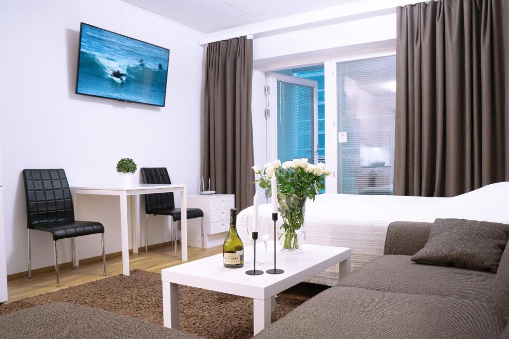 奥卢City center 1R studio with perfect view, parking的客厅配有沙发和鲜花桌
