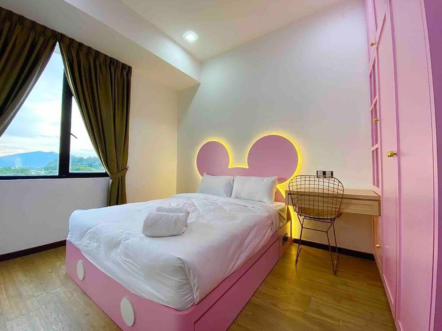 怡保Xii Mountain River View 2R2B 6pax centre of Ipoh的窗户客房内的粉红色床铺
