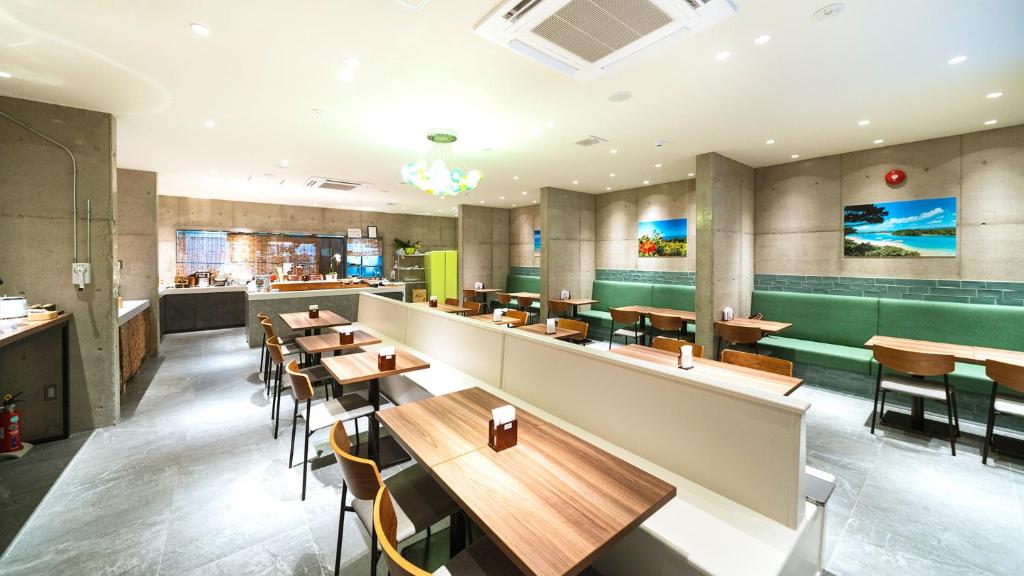 石垣岛The BREAKFAST HOTEL PORTO Ishigakijima的配有木桌和椅子的餐厅