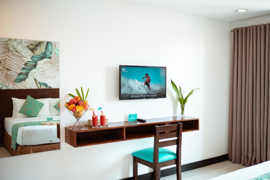 长滩岛乔尼的精品酒店的一间卧室配有一张桌子和一张墙上的电视床。