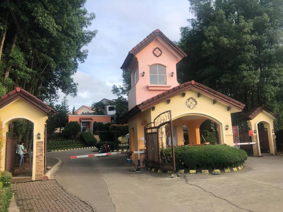 帕加迪安2 storey Camella Homes in Pagadian City的粉红色和白色的建筑,上面有时钟