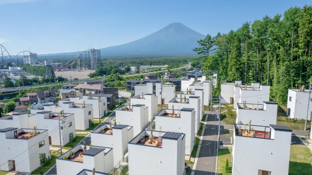 富士吉田市Fuji Gran Villa - TOKI -的享有白色公寓建筑的空中景致,背景为群山