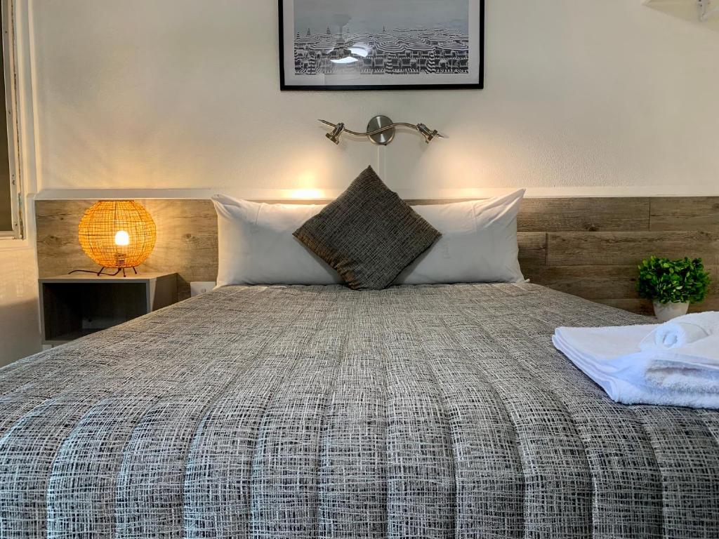 金格罗伊Y Motels Kingaroy的一间卧室配有一张带木制床头板的床
