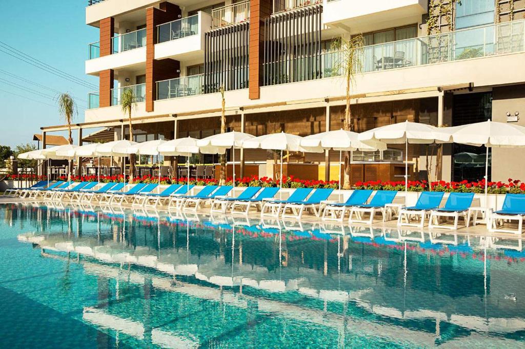 锡德Calimera Side Resort的一个带蓝白色椅子和遮阳伞的游泳池