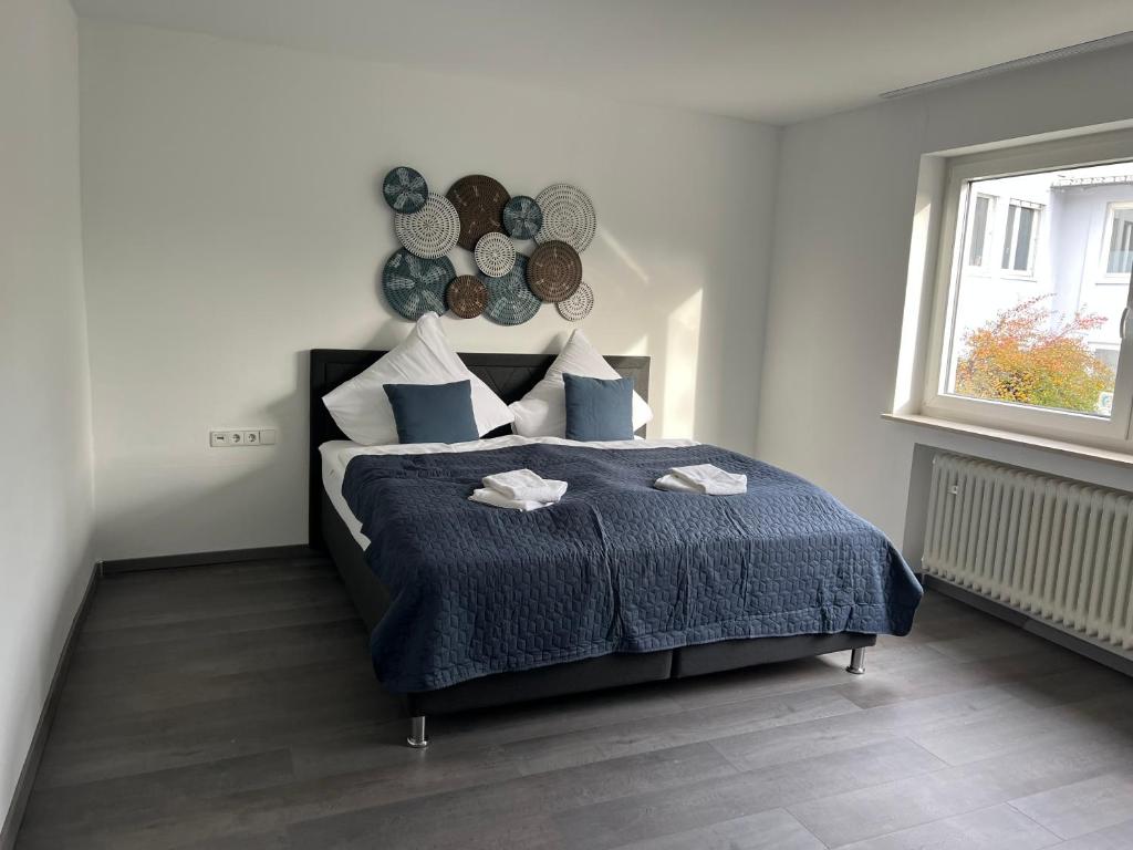 图特林根Unique geräumige 4 Zimmer Wohnung in Tuttlingen mit Netflix, Sauna und Fitness的一间卧室配有一张带蓝色毯子的床和窗户。
