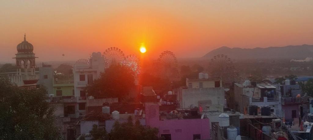 布什格尔Suri Guest House的城市天际线,背景是太阳