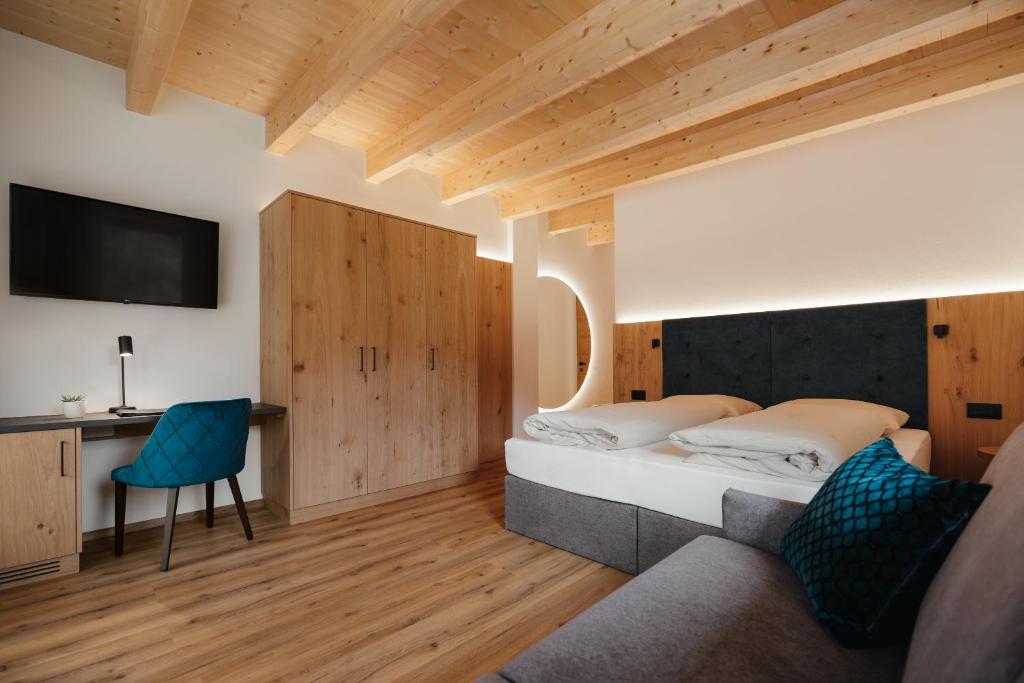 圣维吉利奥Aria de Munt的一间卧室配有一张床、一张书桌和一台电视。