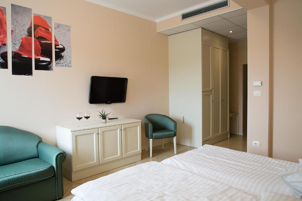 多博沃Hotel Kozana的一间卧室配有一张床、两把椅子和一台电视